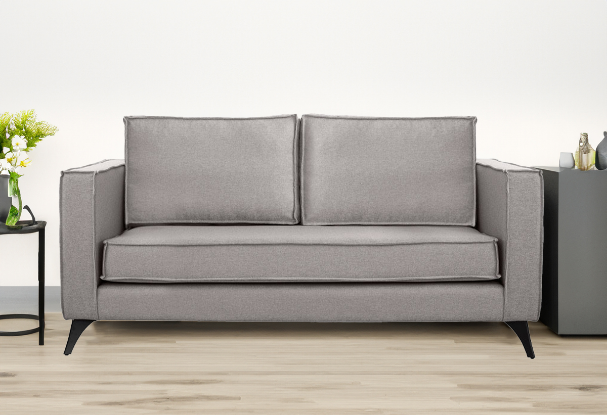 Απεικονίζεται ο μπεζ καναπές τοποθετημένος σε σαλόνι ενώ μπροστά υπάρχει μία μοκέτα.